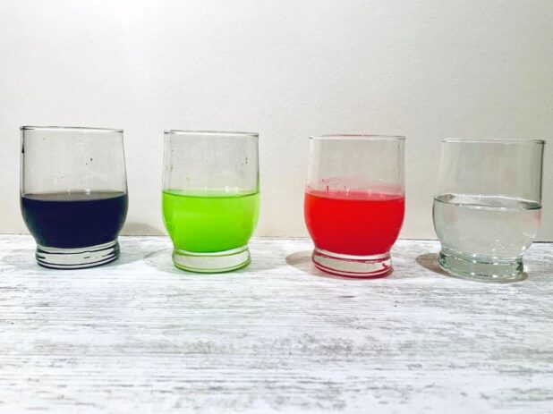 cztery szklanki z płynami różnych kolorów
