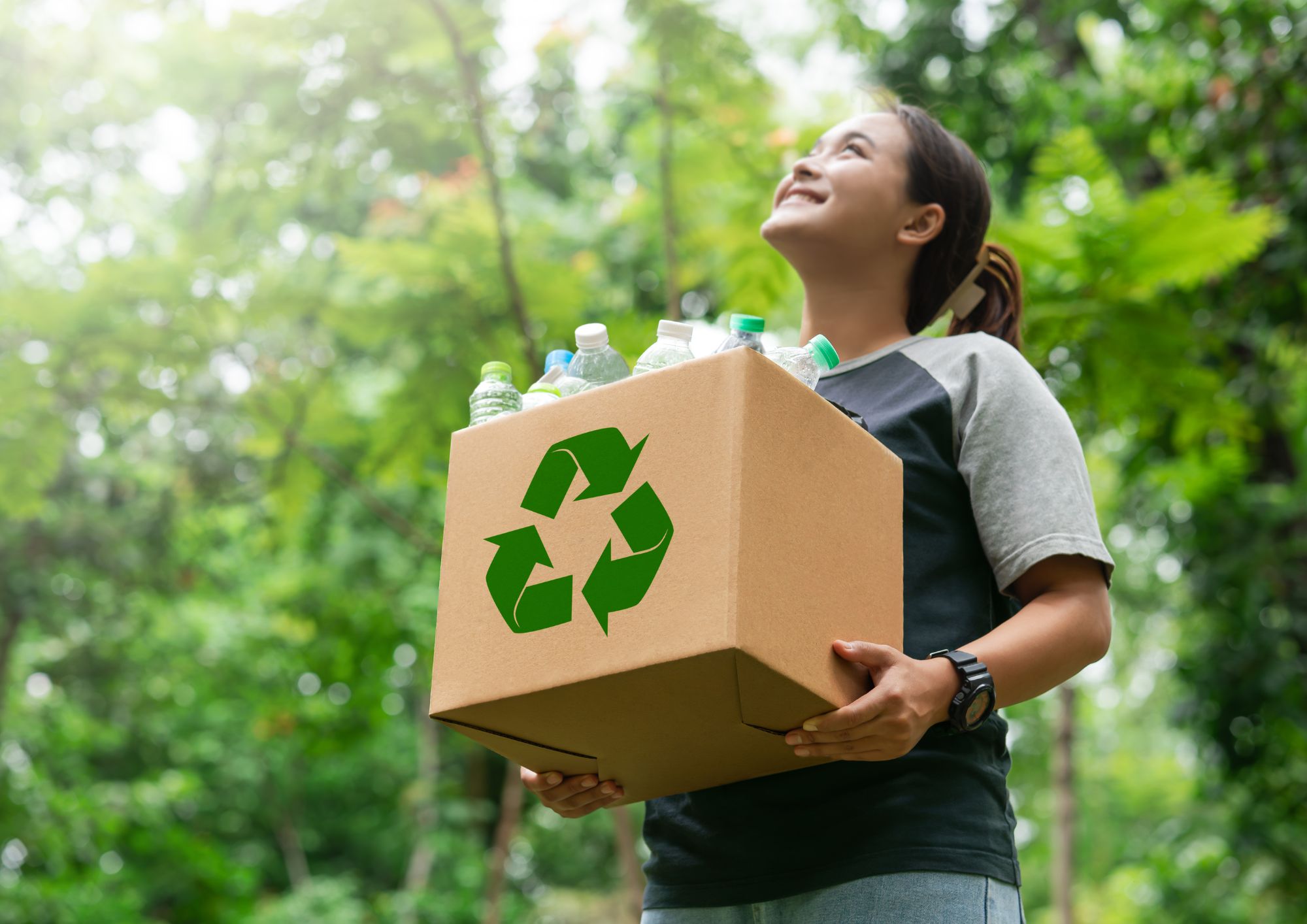recykling dziewczyna trzyma pudełko, na którym widać znak recyklingu