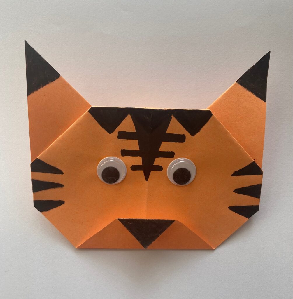 Obraz przedstawia głowę tygrysa, w formie origami